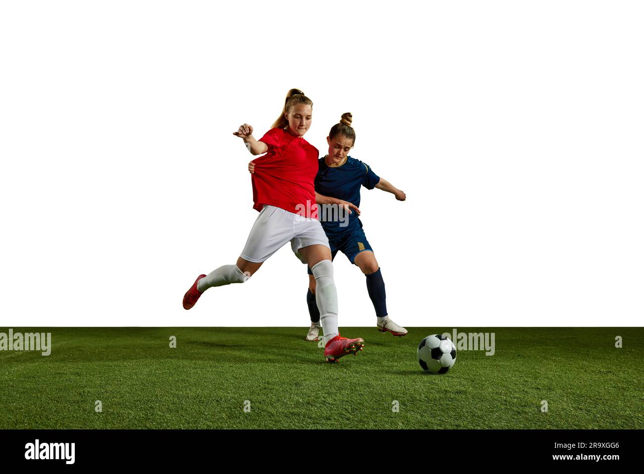 Two young girls, football players in motion, training, dribbling ball