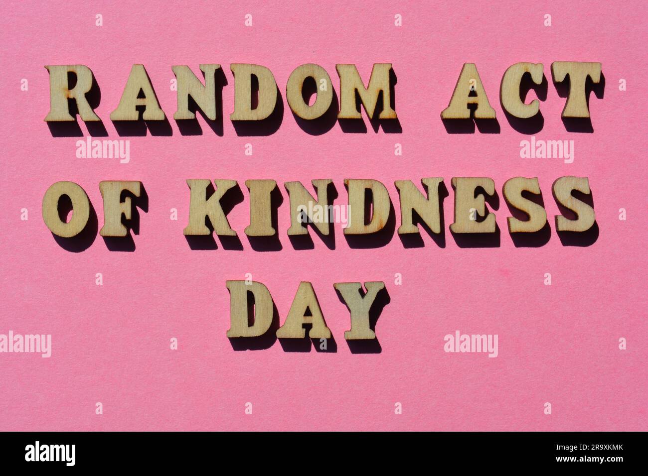 Random Act Of Kindness Day, words in wooden alphabet letters isolated on pink background Stock Photo