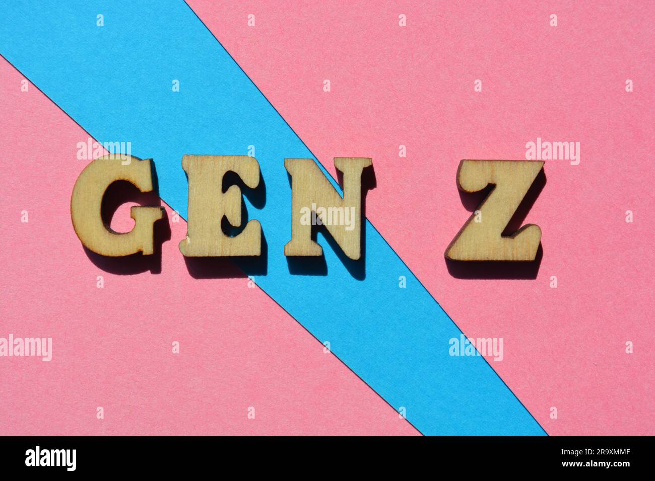 Gen Z, words in wooden alphabet letters isolated on pink and blue background as banner headline Stock Photo