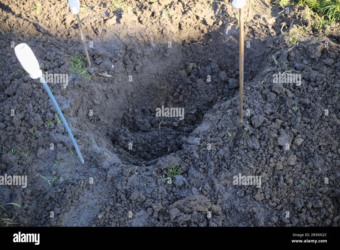 Deep hole being dug on allotment plot in order to create a small wildlife pond Stock Photo