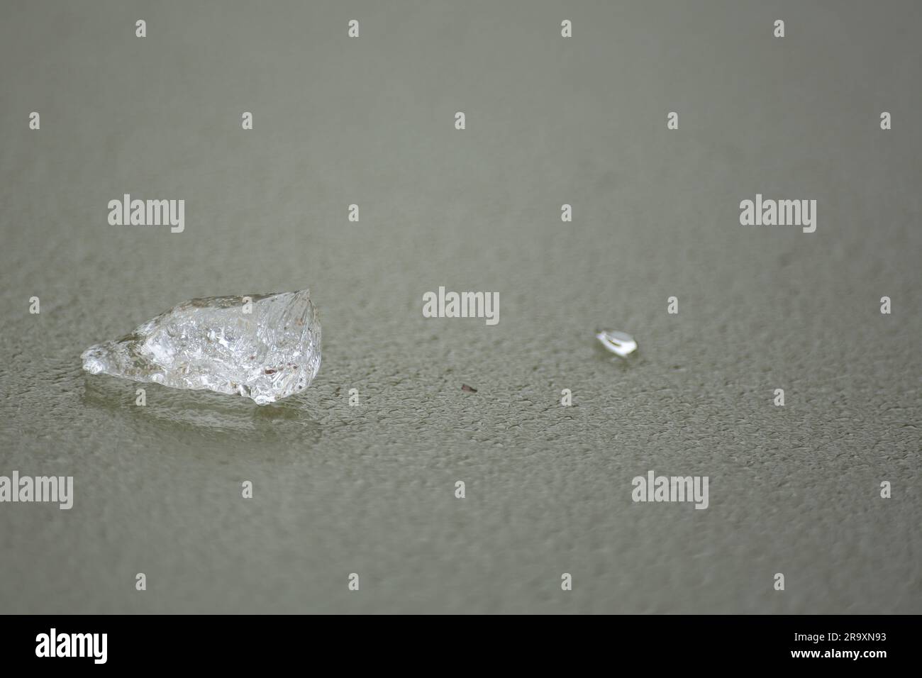 Two transparent chunks of ice on a frozen surface of water Stock Photo