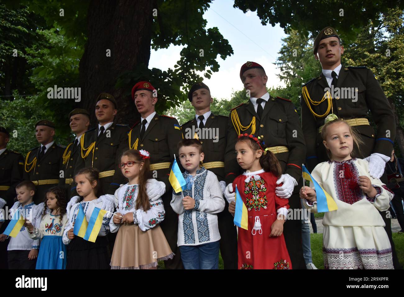 Cadets stand with children during the celebration of the Constitution Day of Ukraine. Ukraine celebrated the 27th anniversary of the adoption of the country's basic law - the constitution. In the conditions of the Russian-Ukrainian war, official events were very short. In Lviv, the Ukrainian flag was raised, honor guard marched, and a military band performed. (Photo by Pavlo Palamarchuk / SOPA mages/Sipa USA) Stock Photo