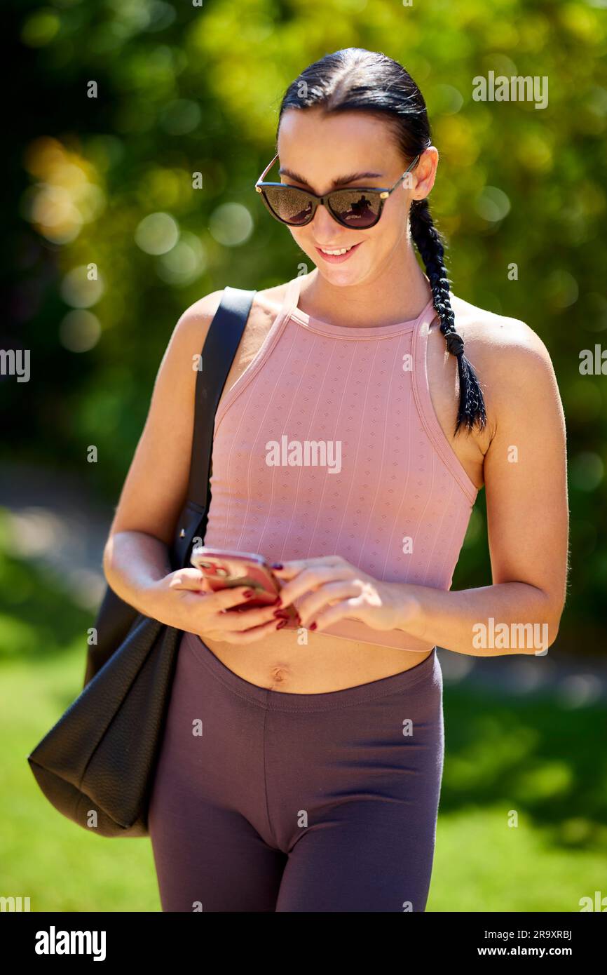 Attractive girl walking outdoors using her phone Stock Photo