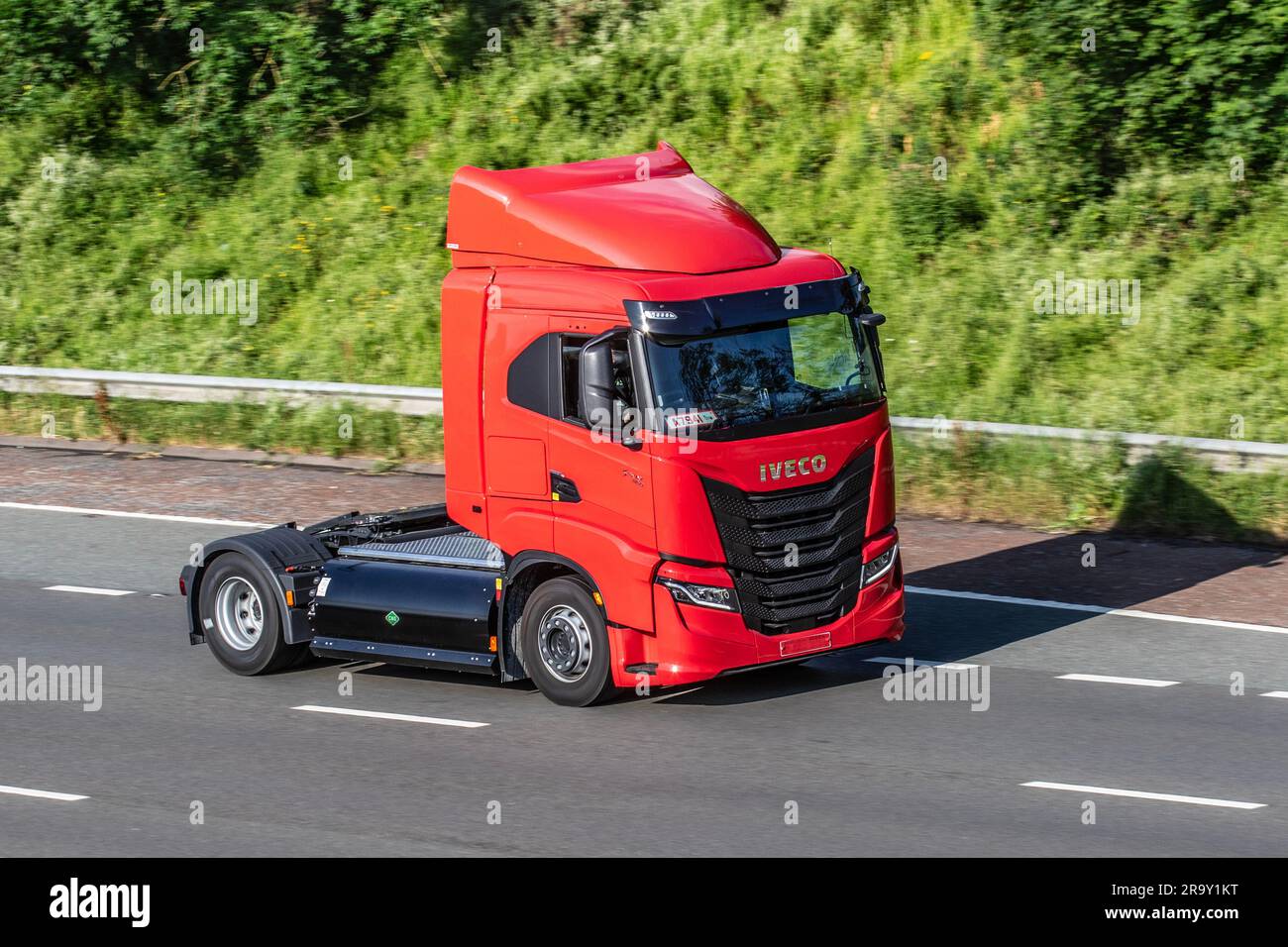 New Red IVECO S-WAY 460  heavy-duty gas truck. Natural gas-powered heavy trucks standard tractor unit; travelling at speed on the M6 motorway in Greater Manchester, UK Stock Photo