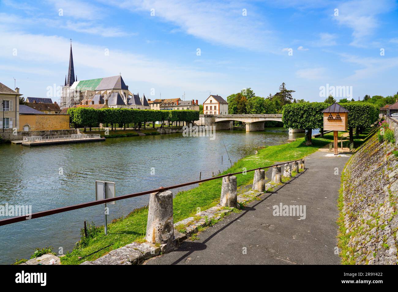 View of the church of Saint John the Baptist seen from the opposite bank of the Loing river in Nemours, a small town in the south of the Seine et Marn Stock Photo