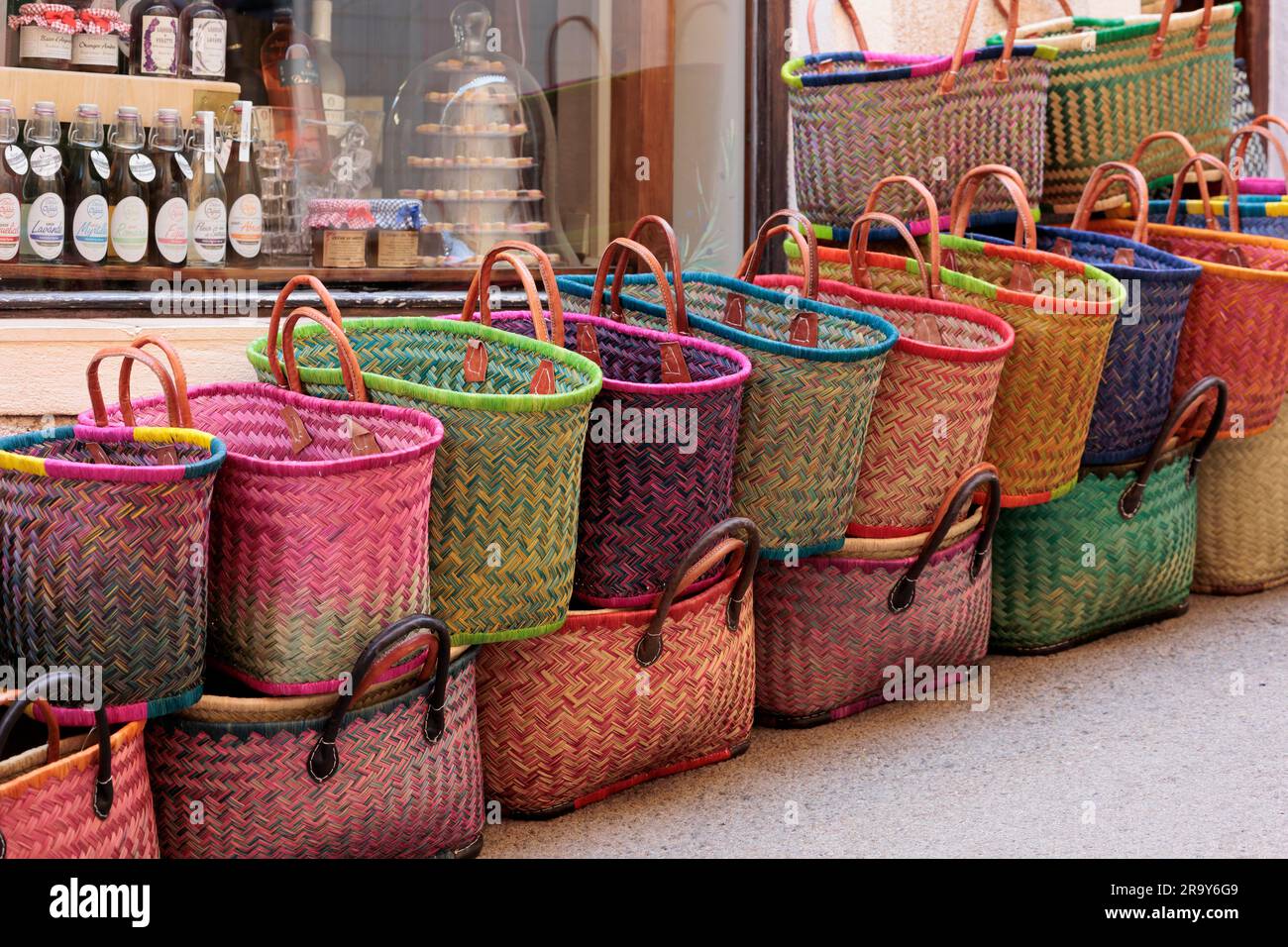 Brightly coloured baskets outside a shop in Moustiers-Sainte-Marie Digne-les-Bains Alpes-de-Haute-Provence Provence-Alpes-Cote d’Azur France Stock Photo