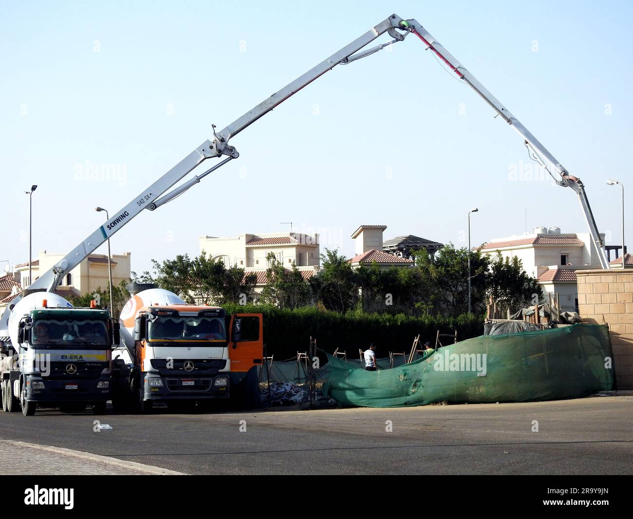 Cairo, Egypt, June 17 2023: A truck-mounted concrete boom pump at the side of the road pouring concrete to a new building, selective focus of concrete Stock Photo