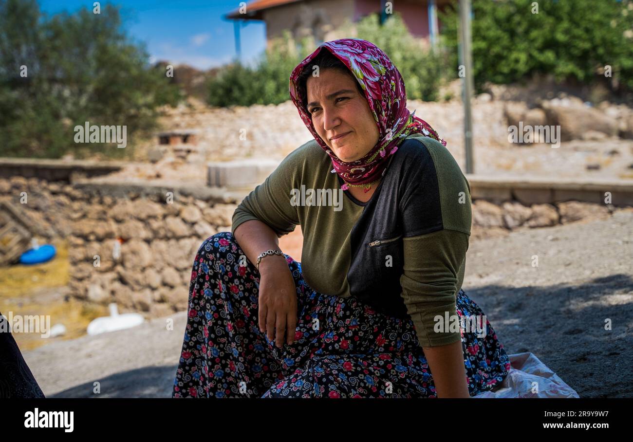 Anatolia, Turkey - September 12, 2021: An old turkish woman wearing scarf covering head in traditional wear sitting outdoors Stock Photo