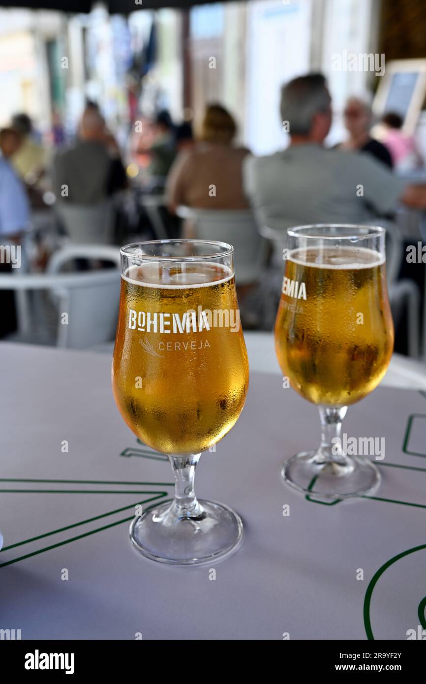 Two Bohemia beers in glasses with people in blurred background behind Stock Photo