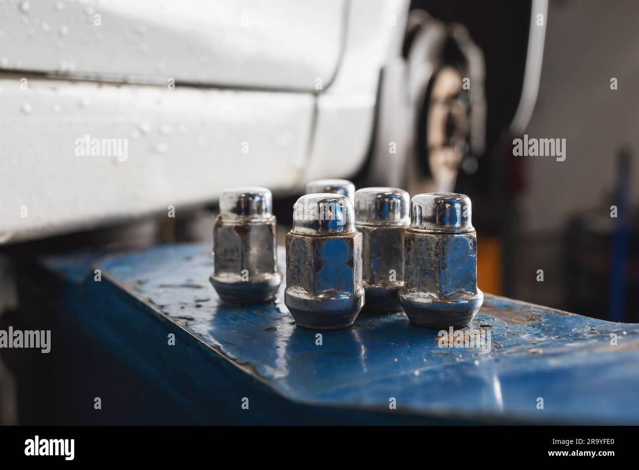 Bolts for car wheels lying in one place on the leg of the lift after