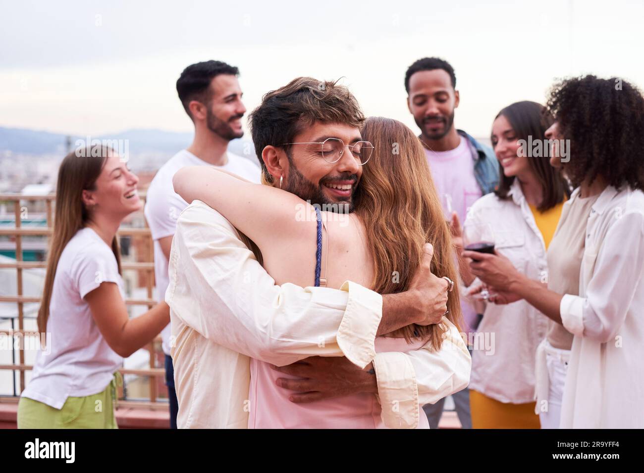 Two friends hugging outdoors during a social gathering Stock Photo - Alamy