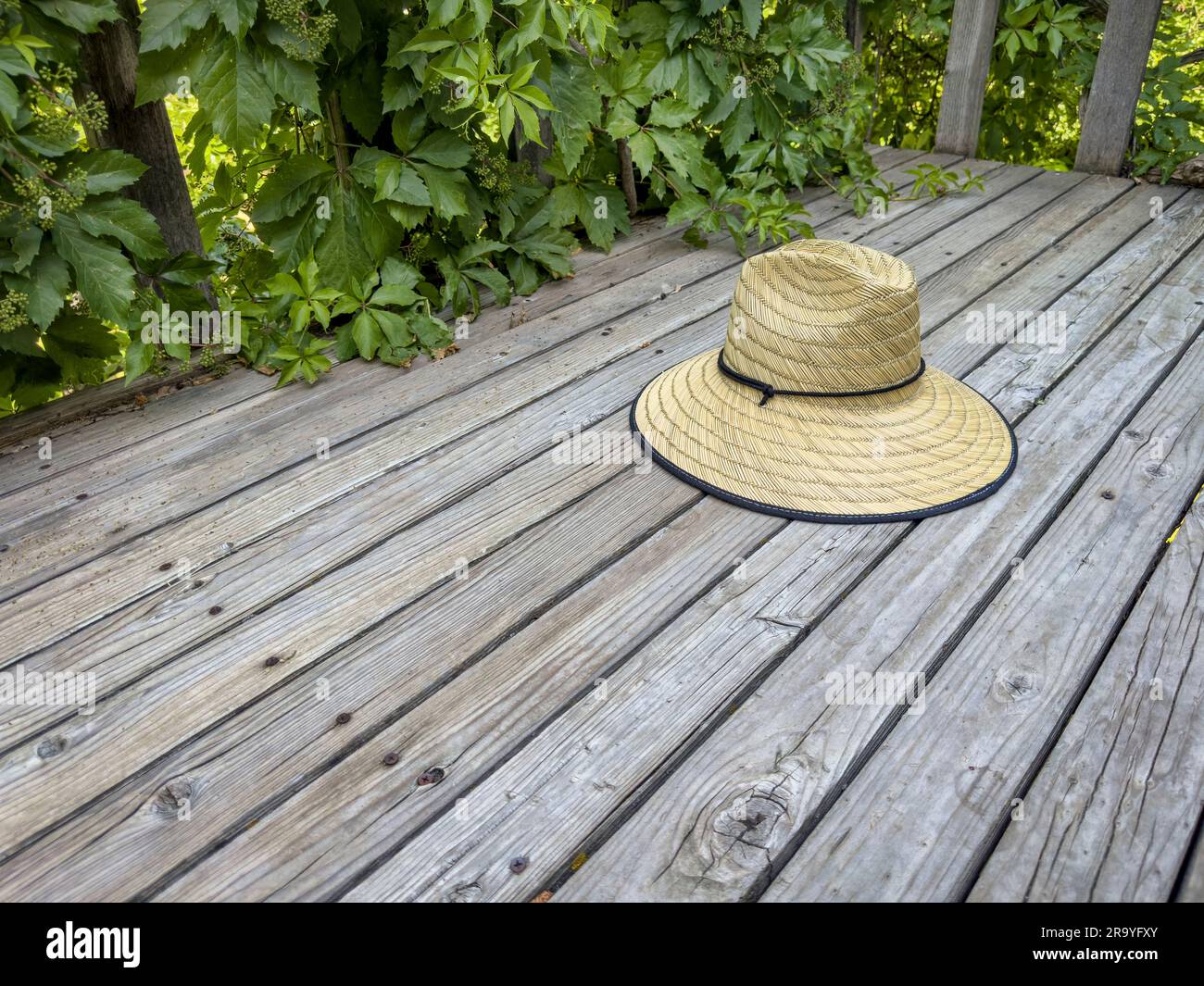 raffia straw sun hat on a rustic wooden backyard deck Stock Photo - Alamy