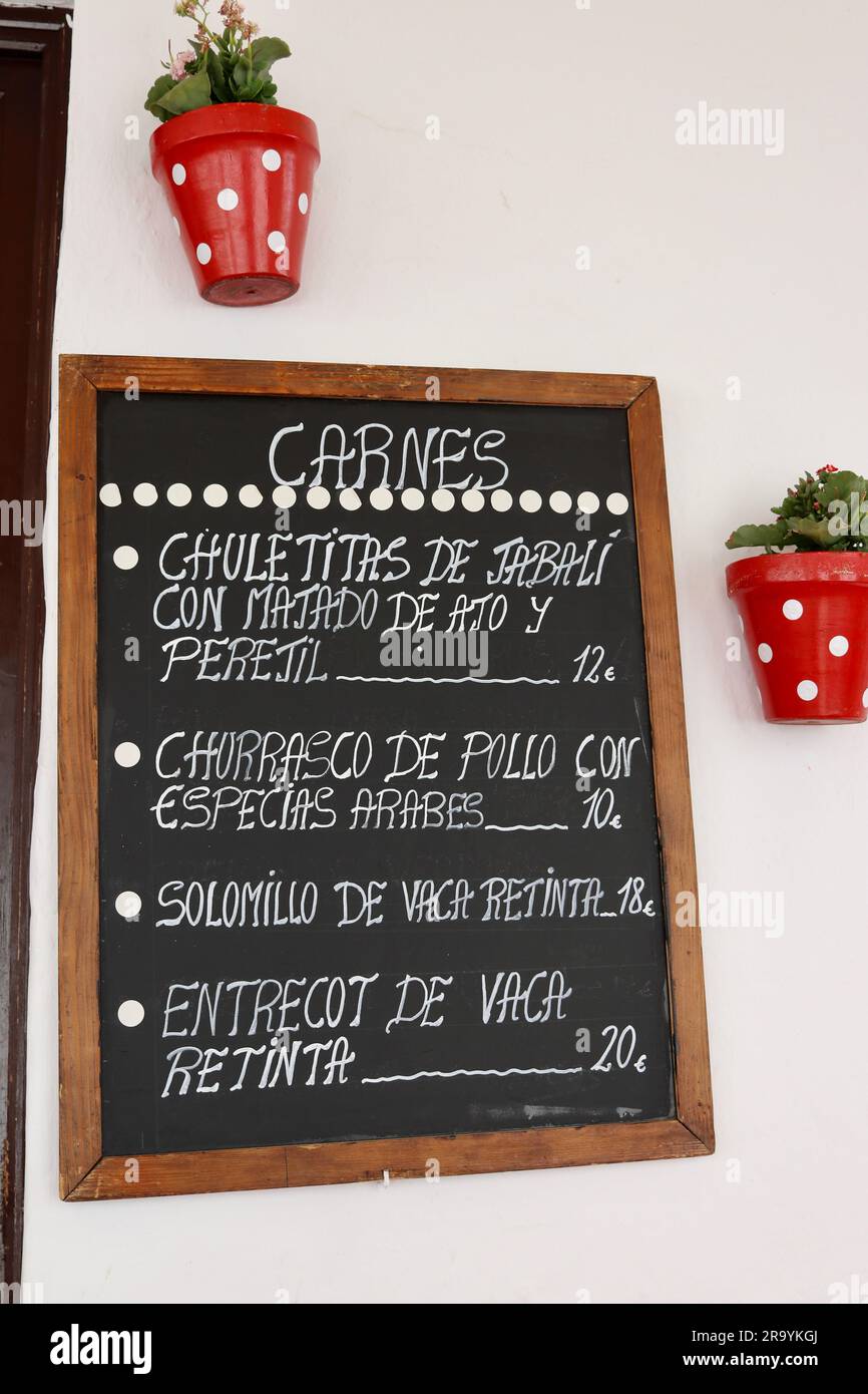 Traditional Spanish meat dish menu at Taberna Jovenes Flamencos, Arcos de la Frontera, Andalusia, Spain Stock Photo