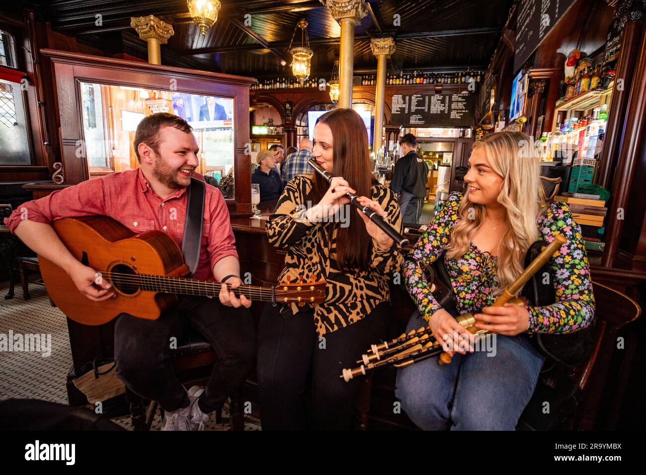 Irish traditional musicians Jack Warnock on guitar, Martha Guiney on flute and Maeve O'Donnell on uileann pipes during the launch of Belfast TradFest McConnell's Irish Whisky Session Trail at the Garrick Bar in Belfast. Picture date: Thursday June 29, 2023. Stock Photo