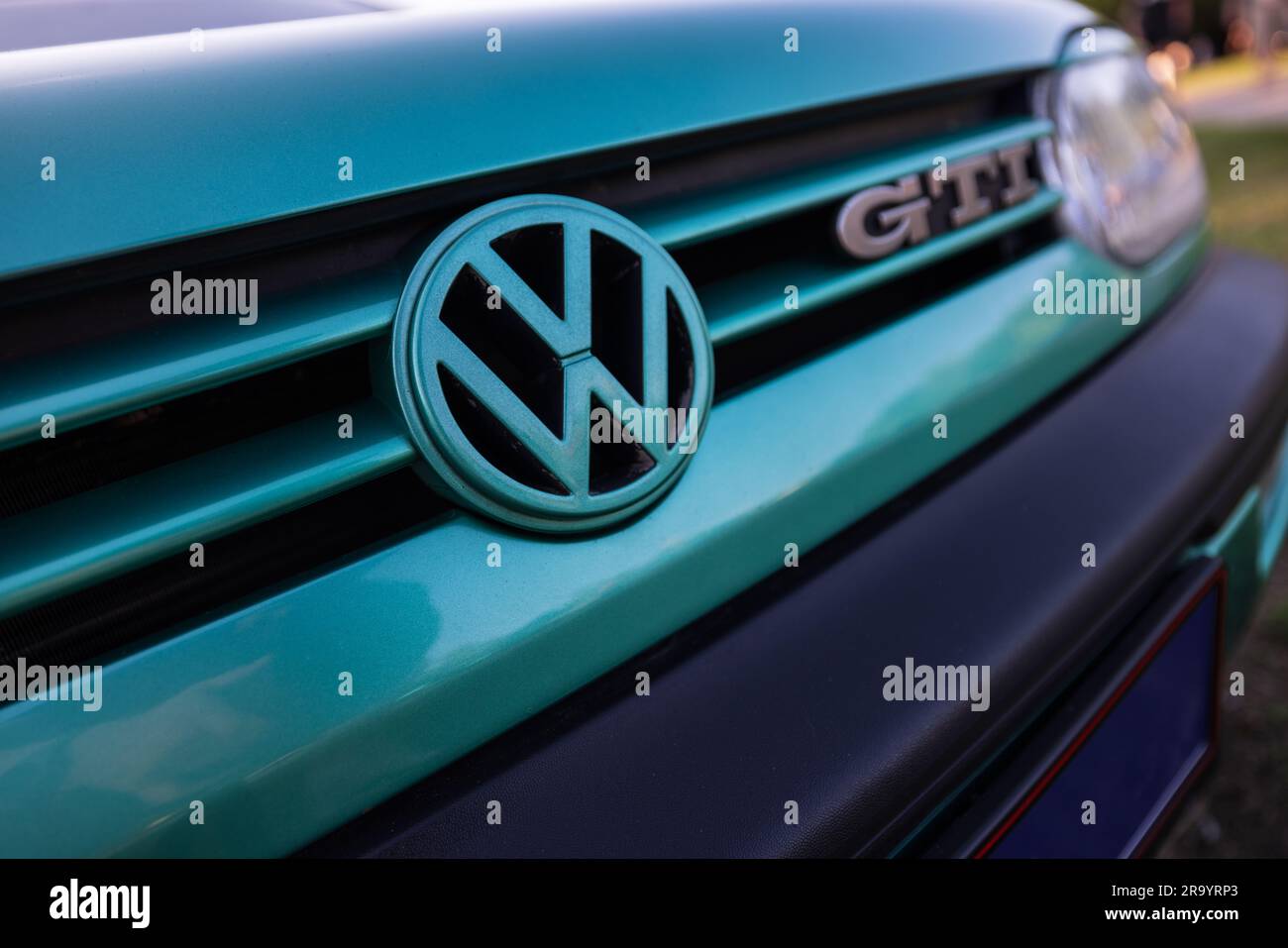 Berlin, Germany - June 24, 2023: Volkswagen logo on a Volkswagen GTI car at a meadow. Stock Photo