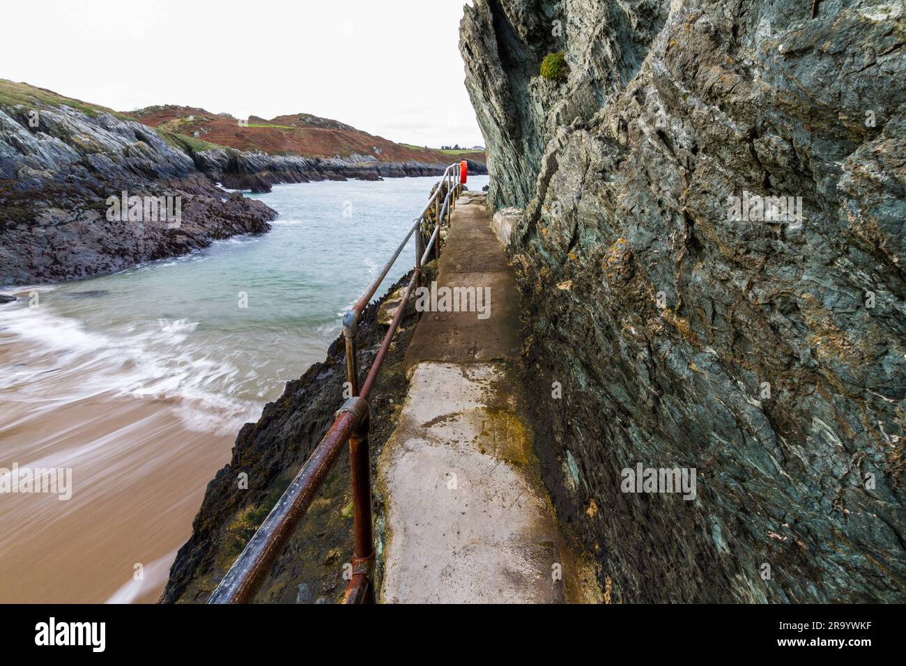 Walkway with Hand Rails at the small bay the Creek or or Traeth Dynion near Amlwch on the north coast of Anglesey. Stock Photo