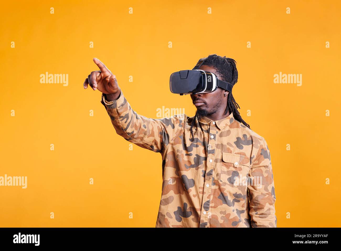 Positive man enjoying virtual reality headset experience, playing with ...