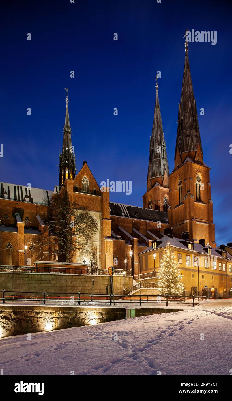 Christmas tree and the cathedral against clear blue sky at night. Uppsala, Sweden. Stock Photo