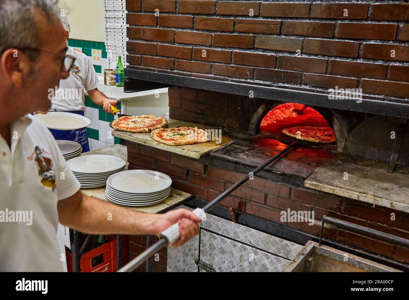 Naples, Italy - October 24, 2019: MICHELIN GUIDE ITALIA. L'Antica Pizzeria da Michele. Naples pizzeria. Naples, Italy. Man making Neopolitan pizza in Stock Photo