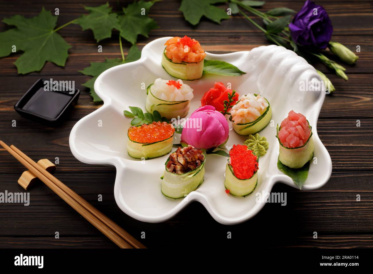 Appetizing gunkani sushi. in assortment. Soy sauce, flowers wooden background Stock Photo