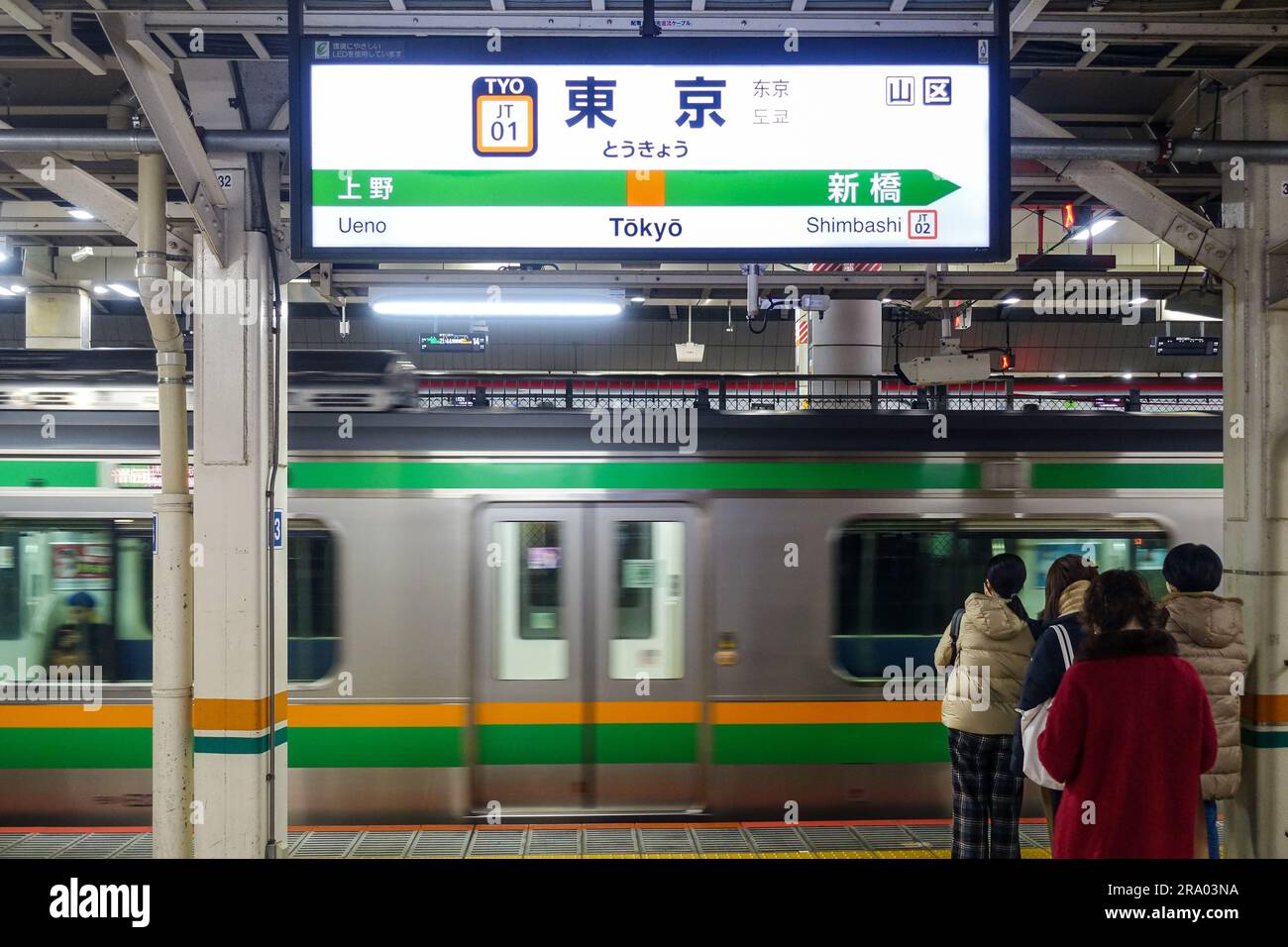 Train and passengers commuting late at night in Tokyo, Japan Stock Photo
