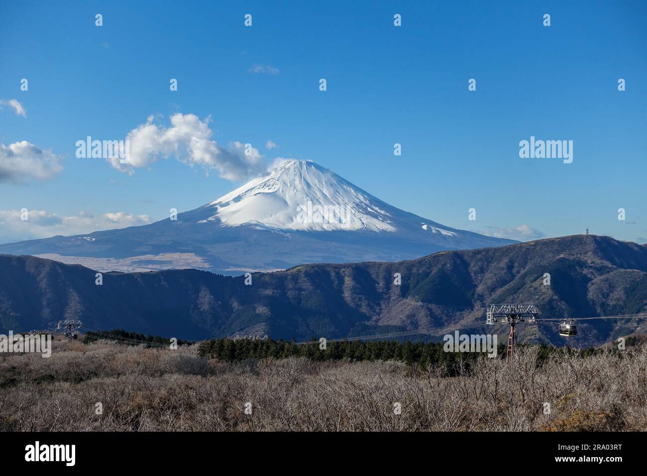 Snow-capped cone-shaped Mount Fuji and the Owakudani cablecar seen from Hakone, Japan, in December Stock Photo