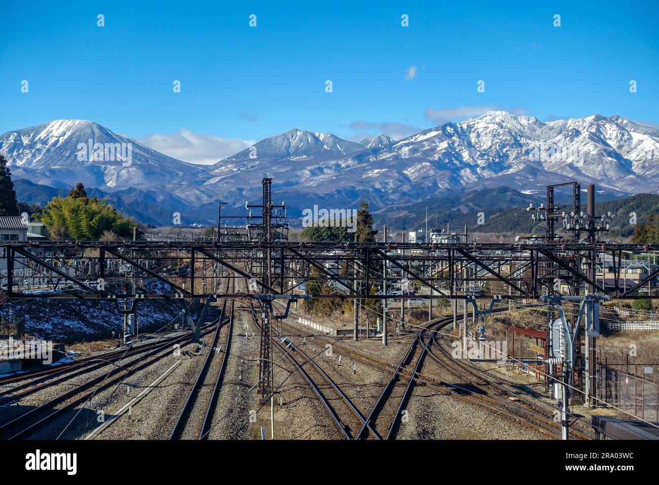 Nikko train station, rails, with snowy Japanese Alps in the backgound ...