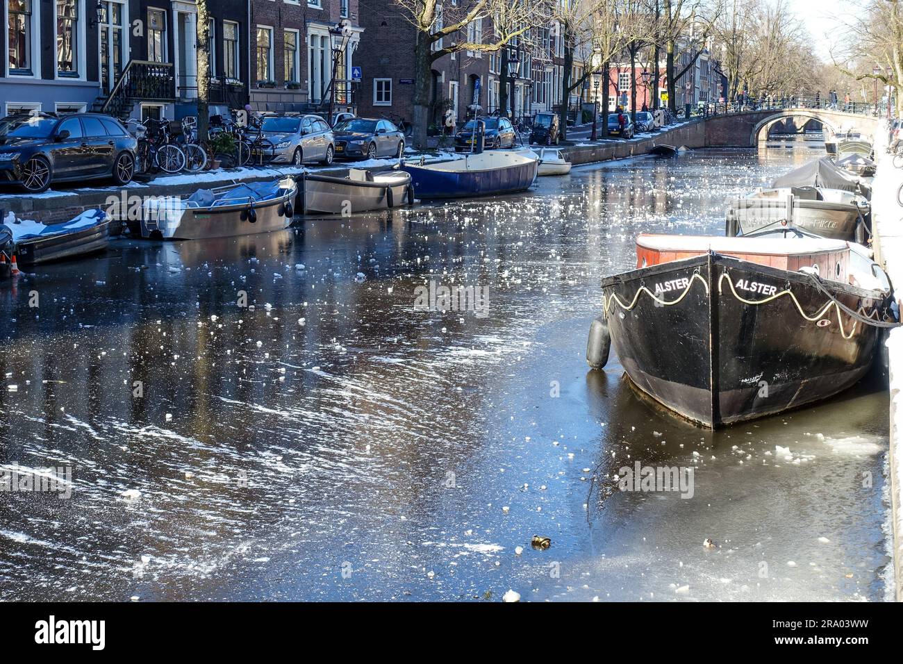 Boats on the frozen canals of Amsterdam during a cold winter day of February 2021 Stock Photo