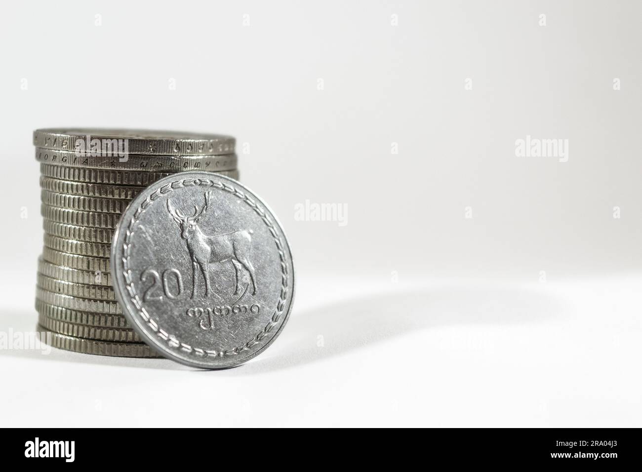 A stack of Georgian Lari coins with a 20 Lari coin leaning on it on a ...