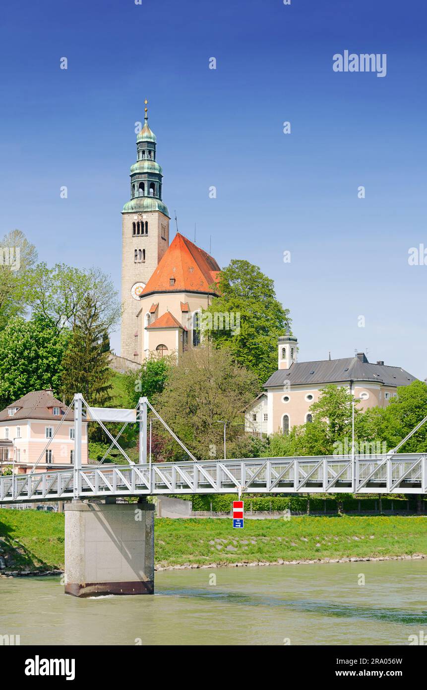 Mülln, small neighborhood in Salzburg, Austria. Pedestrian bridge Müllner Steg over Salzach river, and the Mülln Church Pfarrkirche. Stock Photo