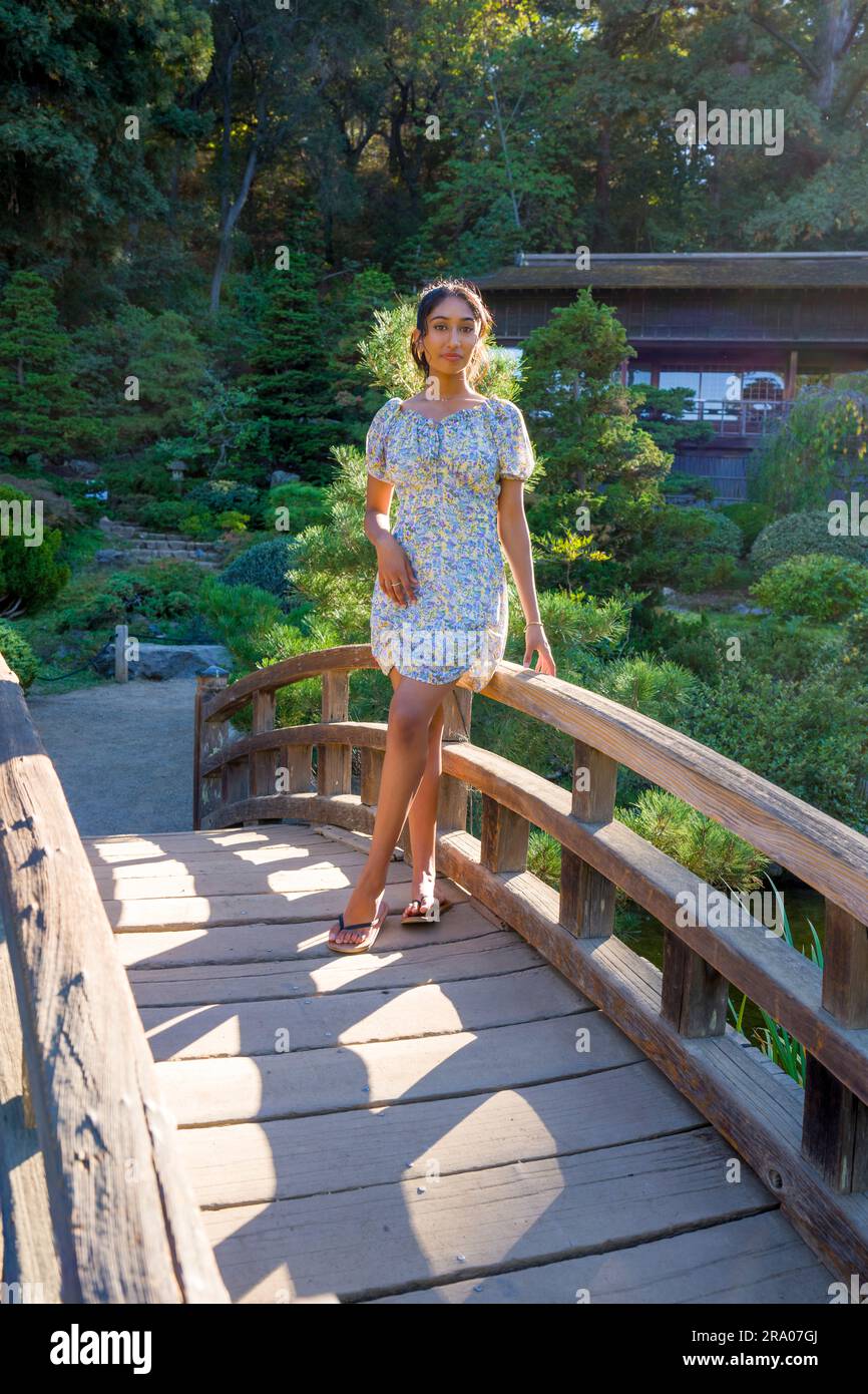 Multiracial Teen Girl Standing on a Bridge in a Japanese Garden | hashi Stock Photo