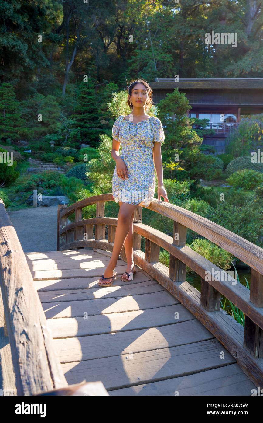 Multiracial Teen Girl Standing on a Bridge in a Japanese Garden | hashi Stock Photo