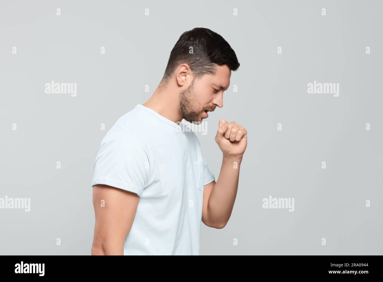 Man coughing on light gray background. Sore throat Stock Photo Alamy