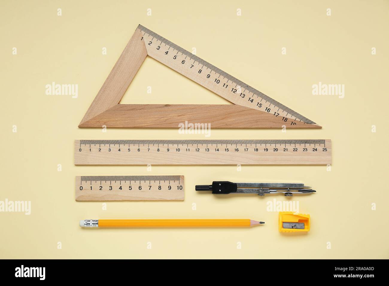 Flat lay composition with different rulers and compass on yellow