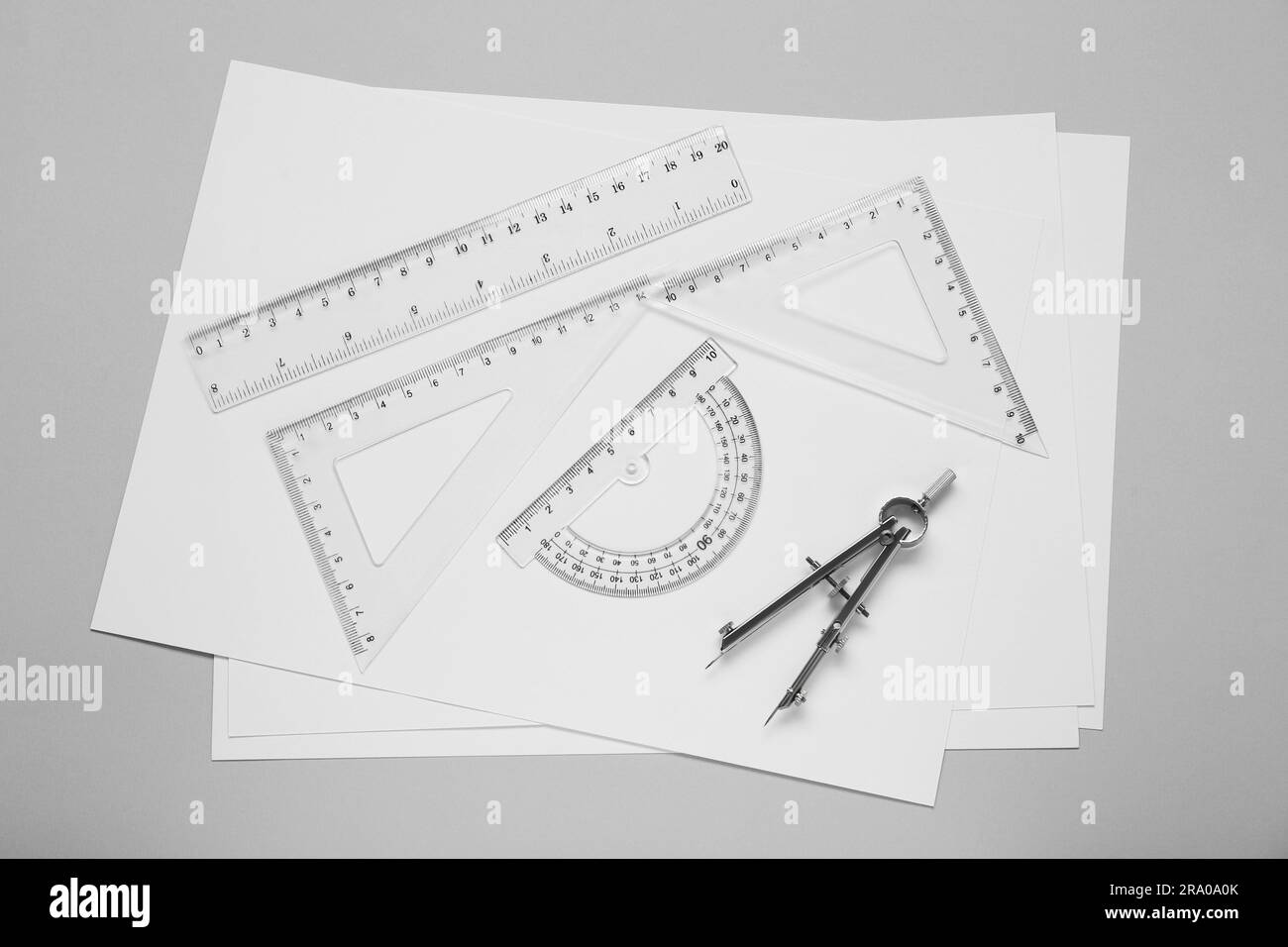Flat lay composition with different rulers and compass on light grey ...