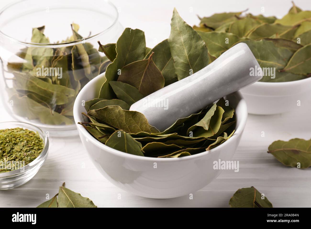 Whole and ground bay leaves on white wooden table, closeup Stock Photo