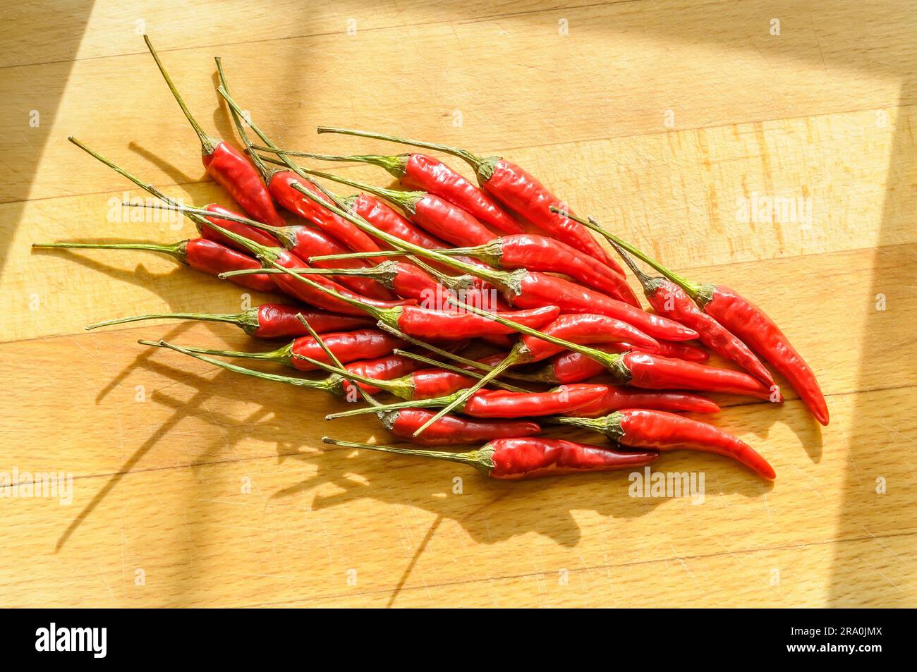 A heap of red hot chili pepper on a cutting board Stock Photo - Alamy