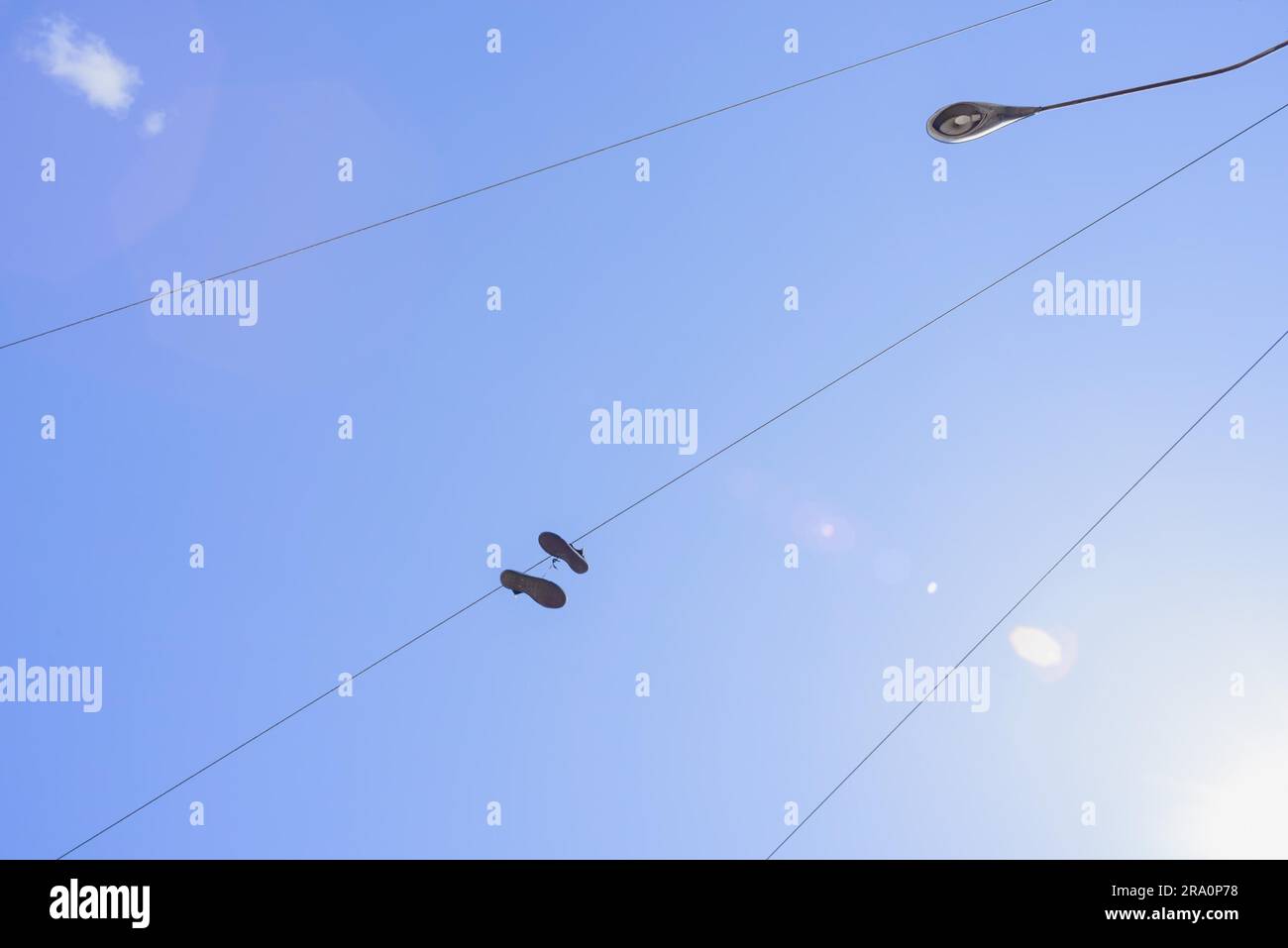 Shoes attached to an electric wire with a blue sky background Stock