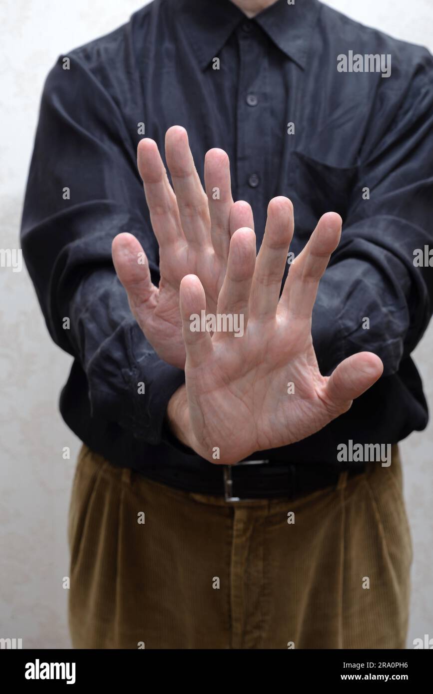 A man saying stop or no with the open hands gesture. Refusing to take the bribe from corrupted people Stock Photo