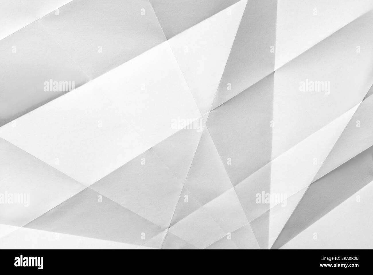White folded sheet of paper showing an abstract texture design under the light grazing. Good to use as background Stock Photo