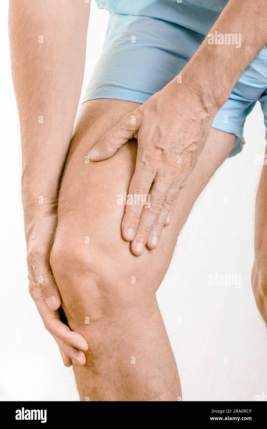 Athlete man massaging a painful quadriceps and the tibia under the knee after an accident. It could a musculaire claquage, a muscle elongation or a Stock Photo