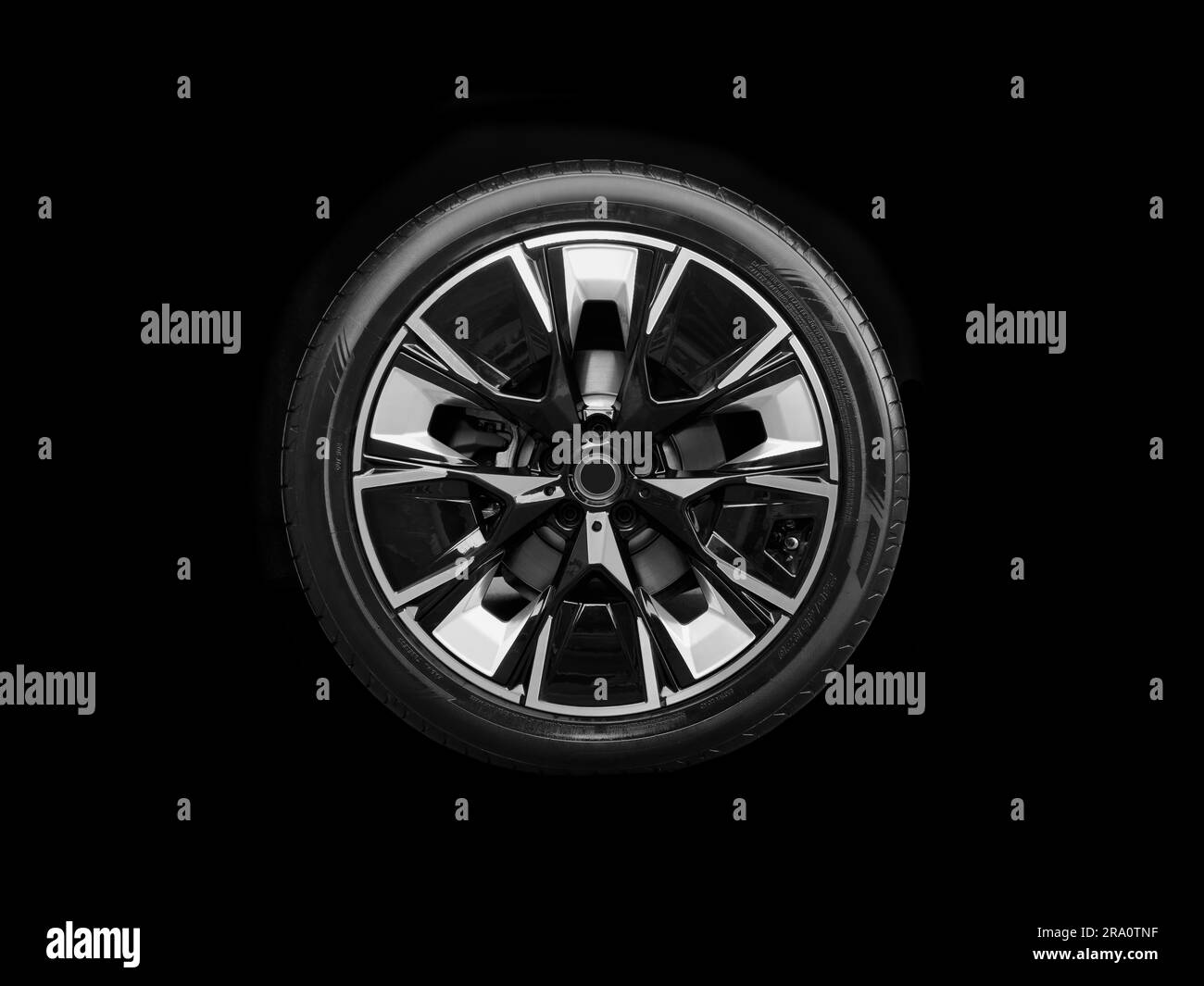 Car alloy wheel and tyre isolated on black background. New alloy wheel