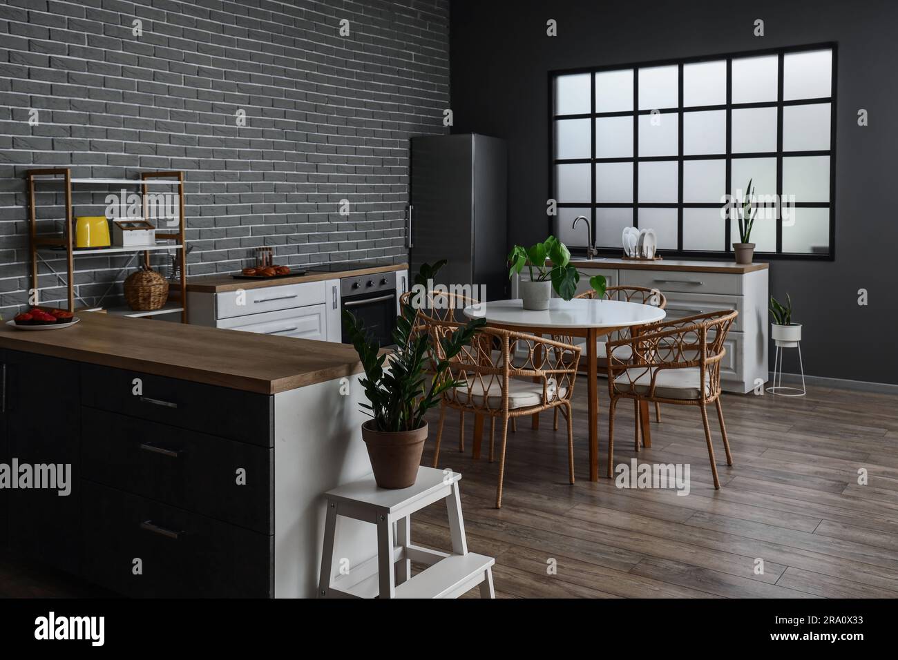 Interior of modern kitchen with dining table, houseplants and kitchen ...