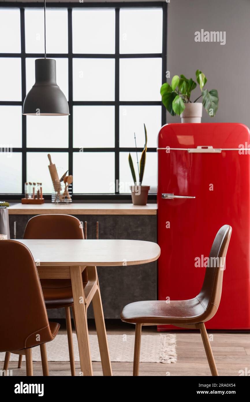 Interior of modern kitchen with dining table, red fridge and window ...