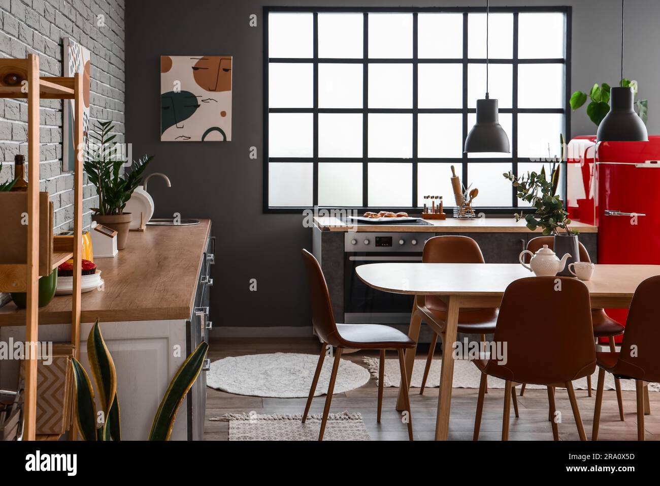 Interior of modern kitchen with dining table and grey counters Stock ...