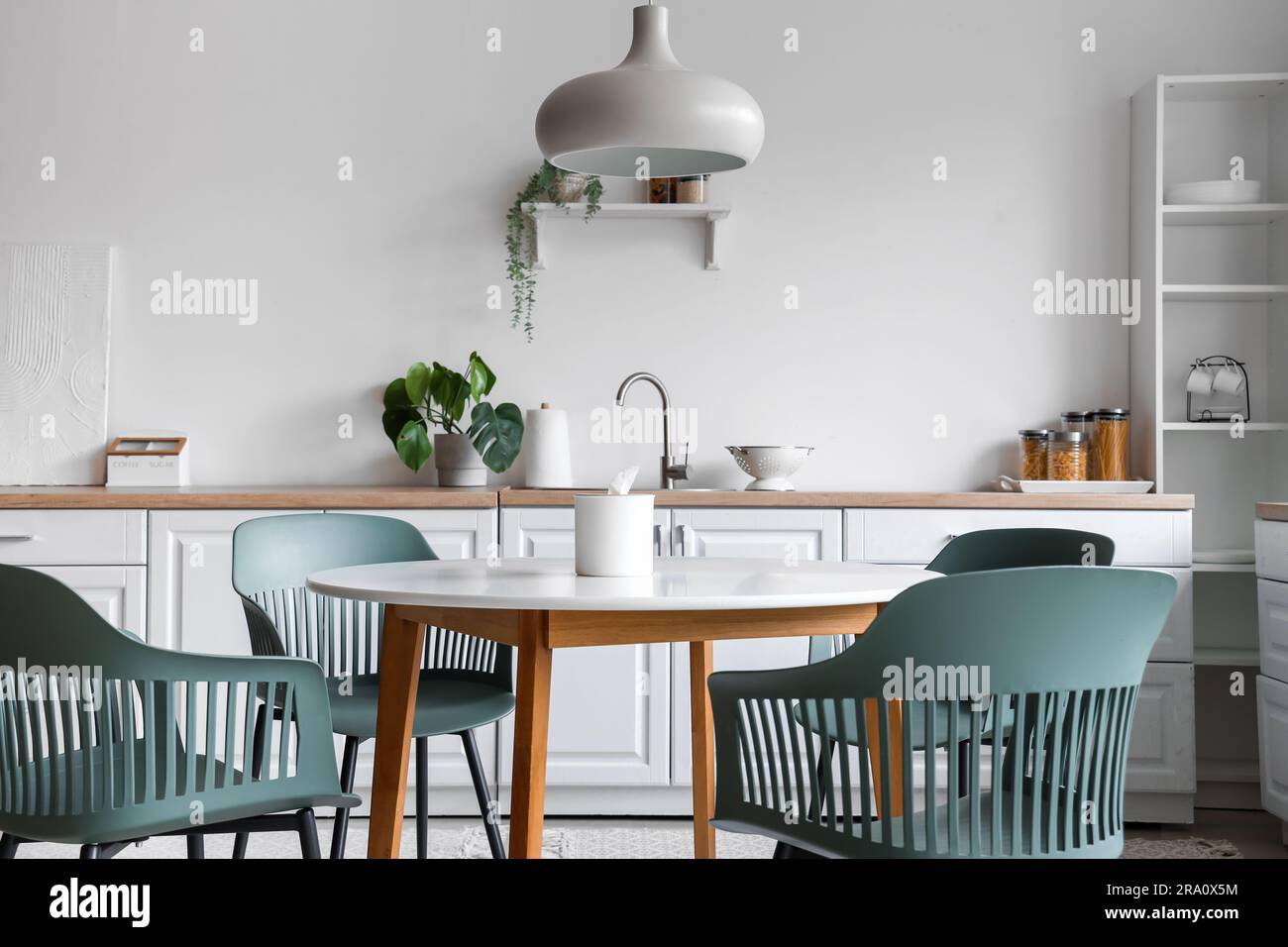 Interior of light kitchen with dining table and white counters Stock ...