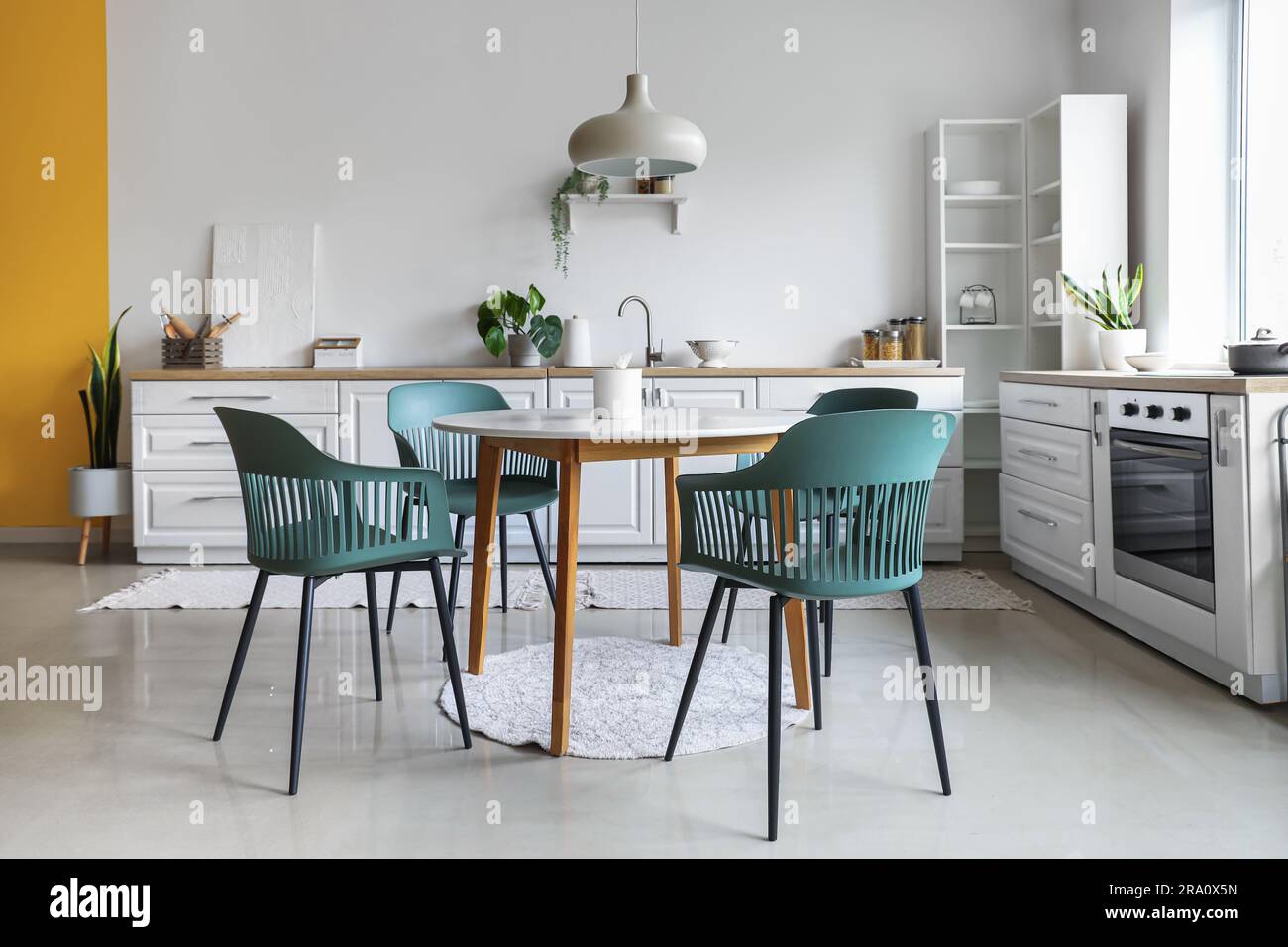 Interior of light kitchen with dining table and white counters Stock ...