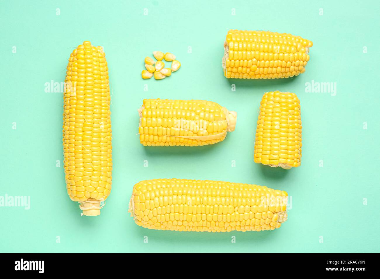 Fresh corn cobs and seeds on turquoise background Stock Photo