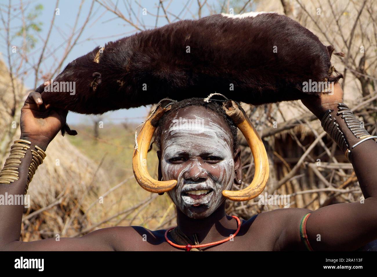 Woman wearing leather bag on head, Mursi tribe, warthog teeth as headdress,  Mago National Park, southern Ethiopia Stock Photo - Alamy