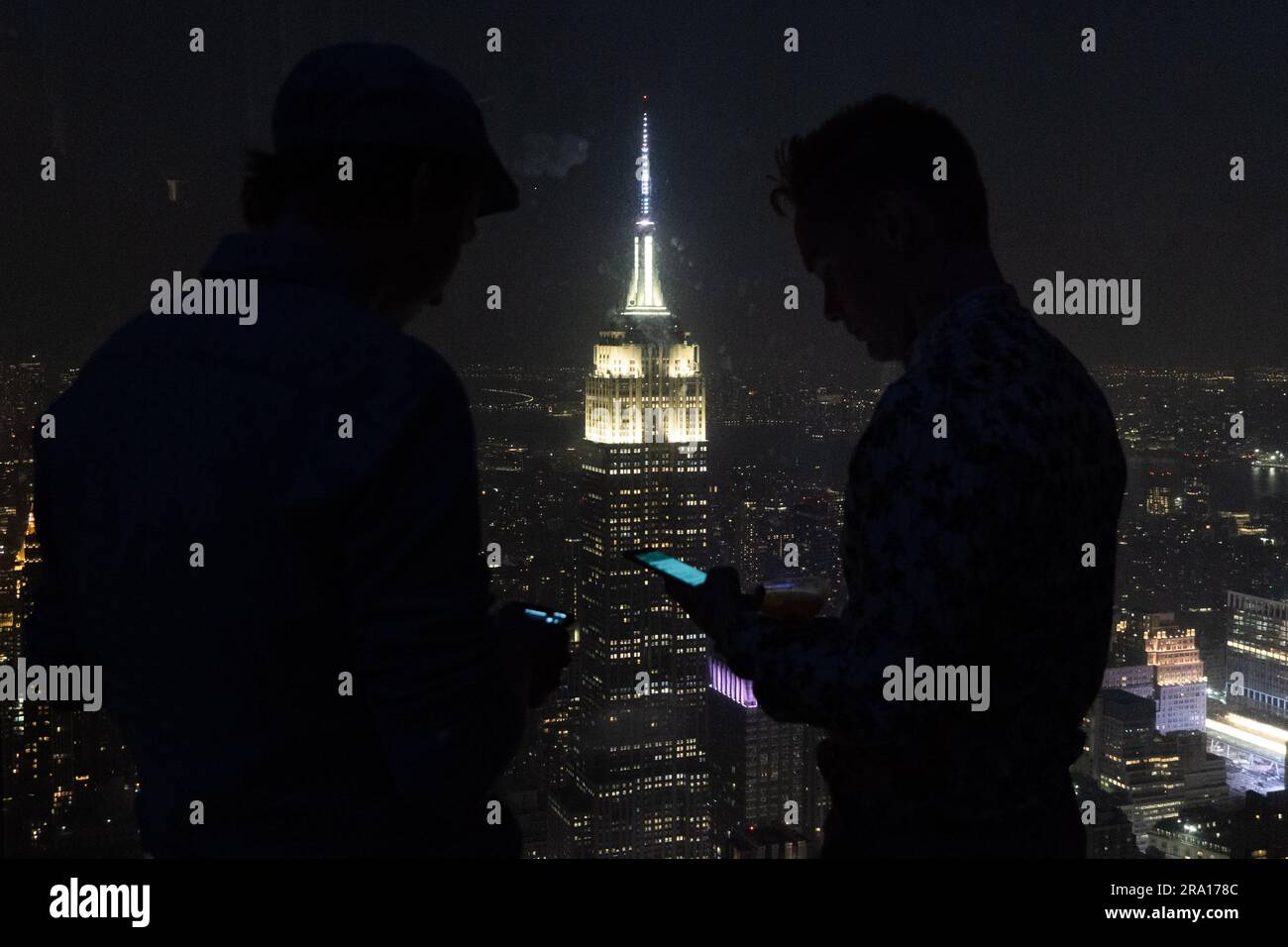 New York, New York, USA. 29th June, 2023. Two men look at their cell
